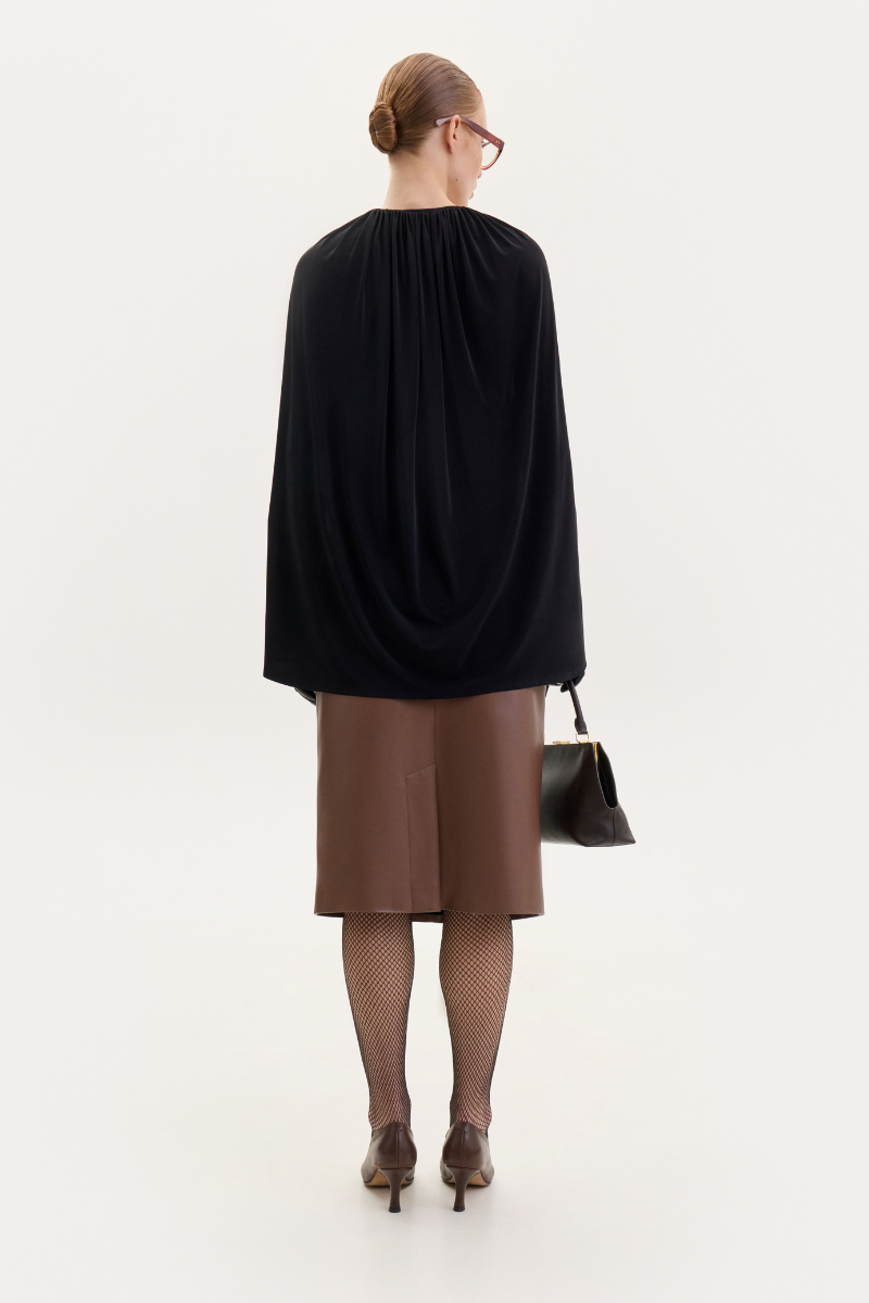 Black jersey cape bodysuit by ELENAREVA, featuring a sleek, fitted design with cape-style shoulders and long sleeves.