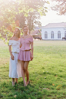 Nana Jacqueline Blakely pink top featuring a stylish design, shown on a model in a fashion campaign.