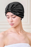 Black silk sleep cap for women by MANITO, featuring a blooming floral design, soft and comfortable hat for restful sleep.