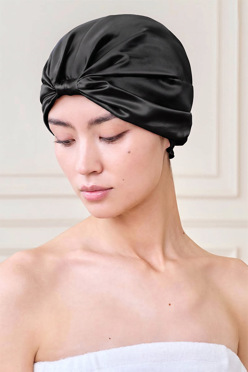 Black silk sleep cap for women by MANITO, featuring a blooming floral design, soft and comfortable hat for restful sleep.