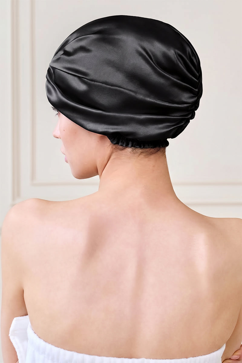 Black silk sleep cap for women by MANITO, featuring a blooming floral design, designed for comfortable, stylish nighttime wear.