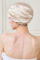 Manito blooming women's silk sleep cap showing a soft, luxurious pink silk hat with floral embroidery for comfortable sleep.