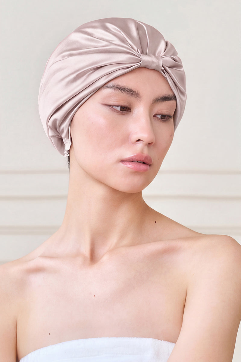 Pink silk sleep cap for women by MANITO, showcasing a blooming floral design, soft fabric, and comfortable fit.