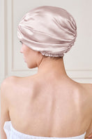 Pink silk sleep cap for women by MANITO, stylish hat designed for comfortable, luxurious sleepwear.