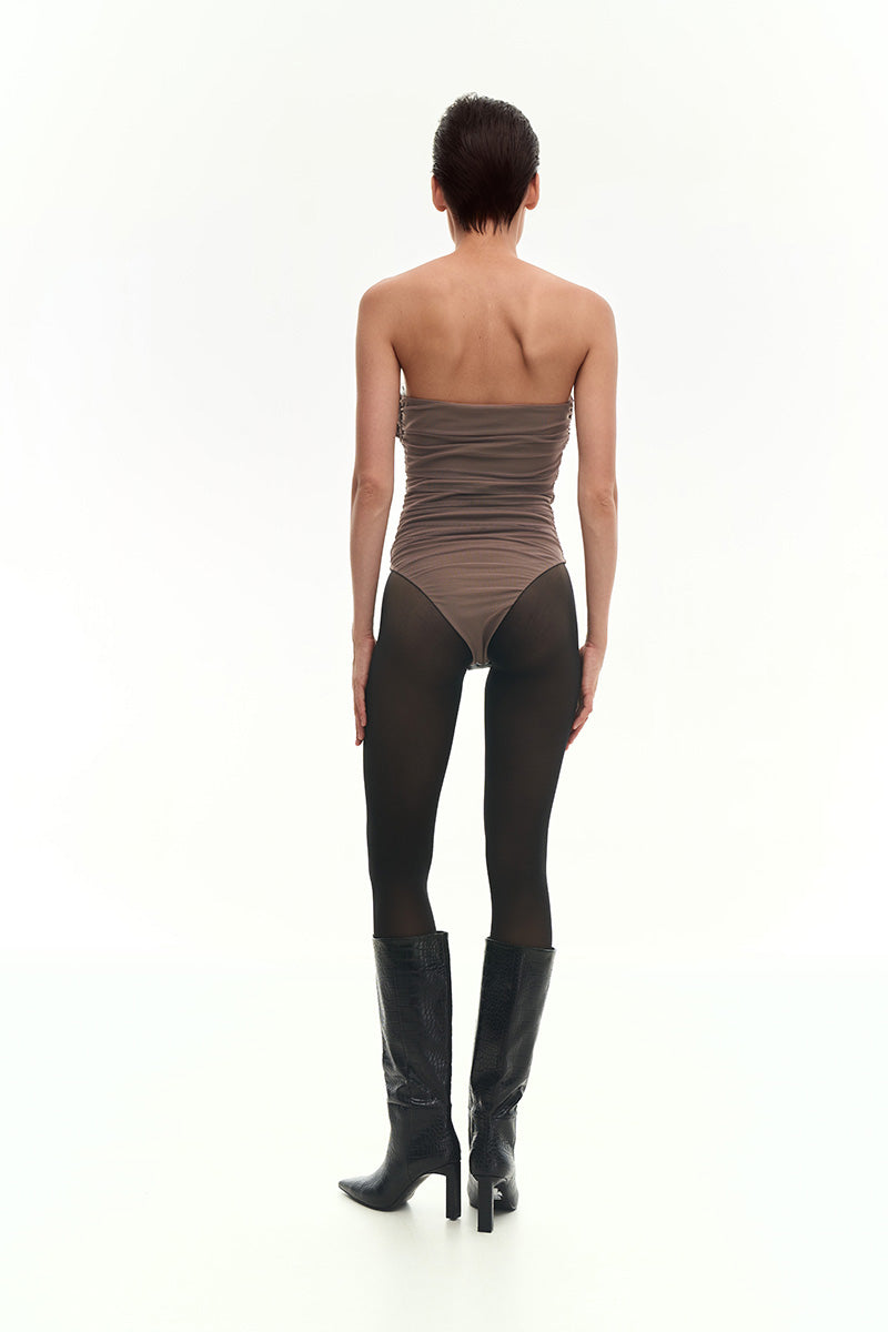 Brown draped bustier bodysuit with a flower applique by KRIS MARÁN, showcasing elegant fabric draping and floral detail.