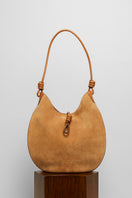 Beige suede boho shoulder bag by Folklore The Label with woven strap detail and relaxed, stylish design.