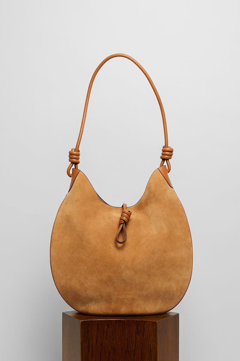 Beige suede boho shoulder bag by Folklore The Label with woven strap detail and relaxed, stylish design.