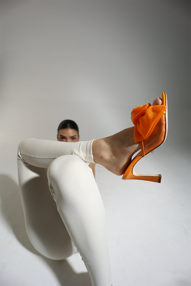 Orange patent bow mule sandals by House of Atana, featuring a stylish bow detail and open-toe design.