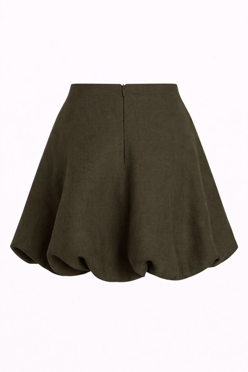 Lichen green Brie mini skirt by ANA + MARIA, shown on a model, featuring a fitted silhouette and stylish design.
