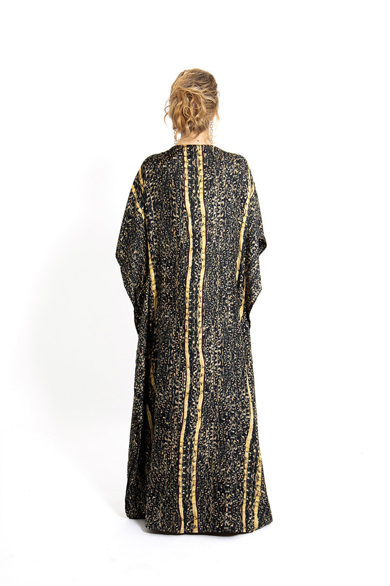 Back view of brown Brocot kaftan maxi dress by Amel Batita, featuring flowing fabric and intricate brocot pattern.