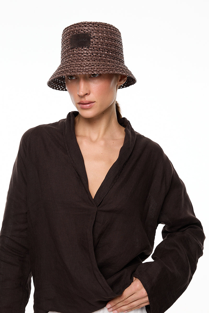 Brown bucket hat by LE SH KA featuring a classic wide-brim design and soft brown fabric for casual style.