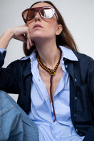Pájara Pinta Guardian Snake necklace in brown with a detailed snake pendant on a chain, styled as a statement jewelry piece.