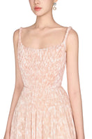 Beige pleated maxi dress by Montsand, flowing fabric with a full-length skirt and elegant pleats, displayed on a hanger.