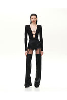 Black Kris Marán buckle bodysuit with cutouts, featuring sleek design and adjustable straps, shown on a model.