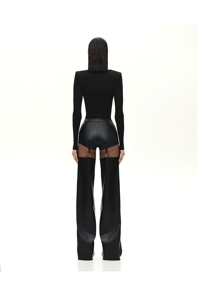 Black Kris Marán buckle bodysuit with cutouts, featuring sleek straps and modern design, worn as a stylish top.
