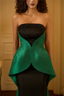 Green crepe and taffeta gown by I.H.F with waist cinching and draped detail, shown on a model.
