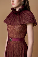 Elegant Bordeaux lace gown by I.H.F featuring a bustier, A-line silhouette, and mini cape with intricate guipure lace details.
