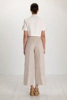 Tan button pants by ANA + MARIA featuring a front button closure and a relaxed fit, shown in size 2.