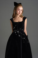 Black velvet A-line midi gown by I.H.F Studio featuring a sleek silhouette and elegant design, displayed on a dress form.