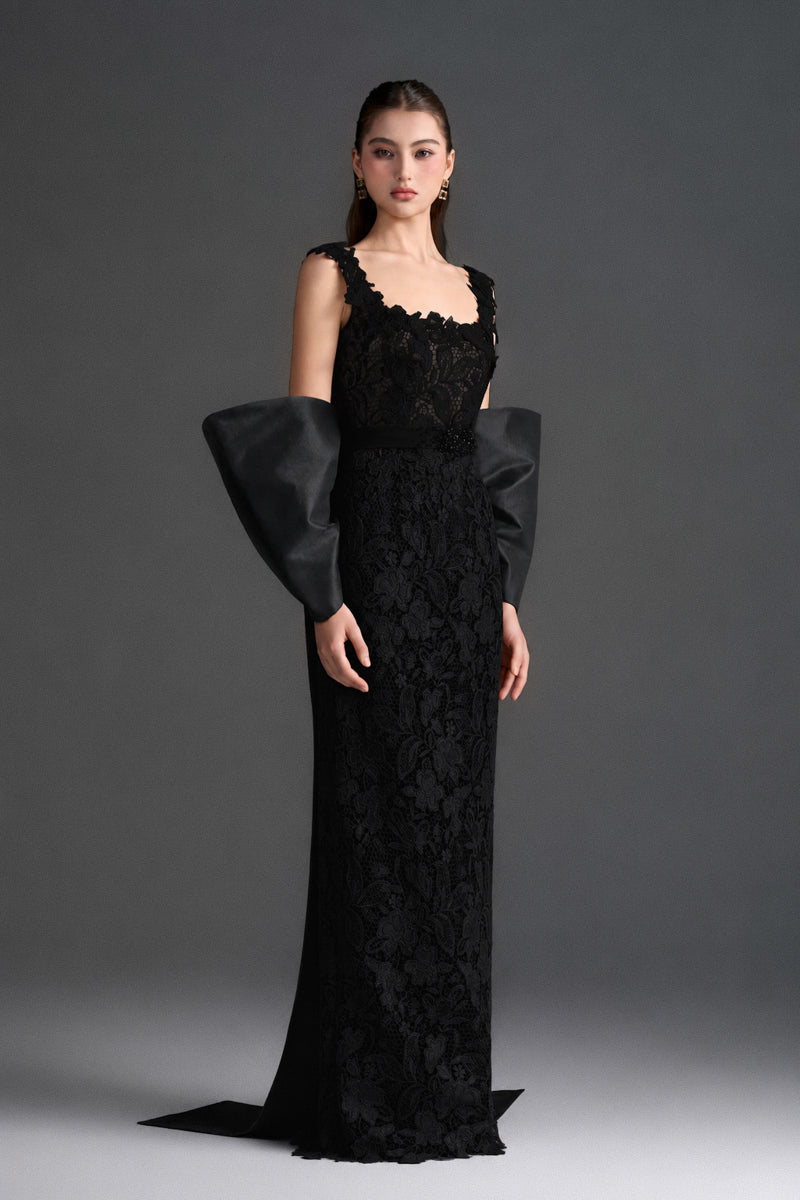 Black floral lace gown with square neckline and large back bow, designed by I.H.F Studio, featuring a sleek column silhouette.