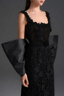 Black floral lace gown with square neckline and large back bow by I.H.F Studio, featuring a sleek column silhouette.