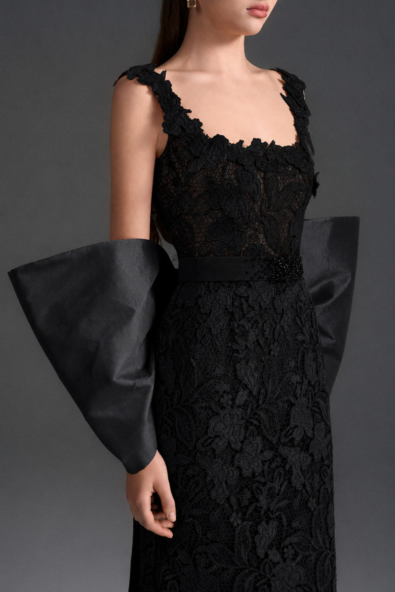 Black floral lace gown with square neckline and large back bow by I.H.F Studio, featuring a sleek column silhouette.