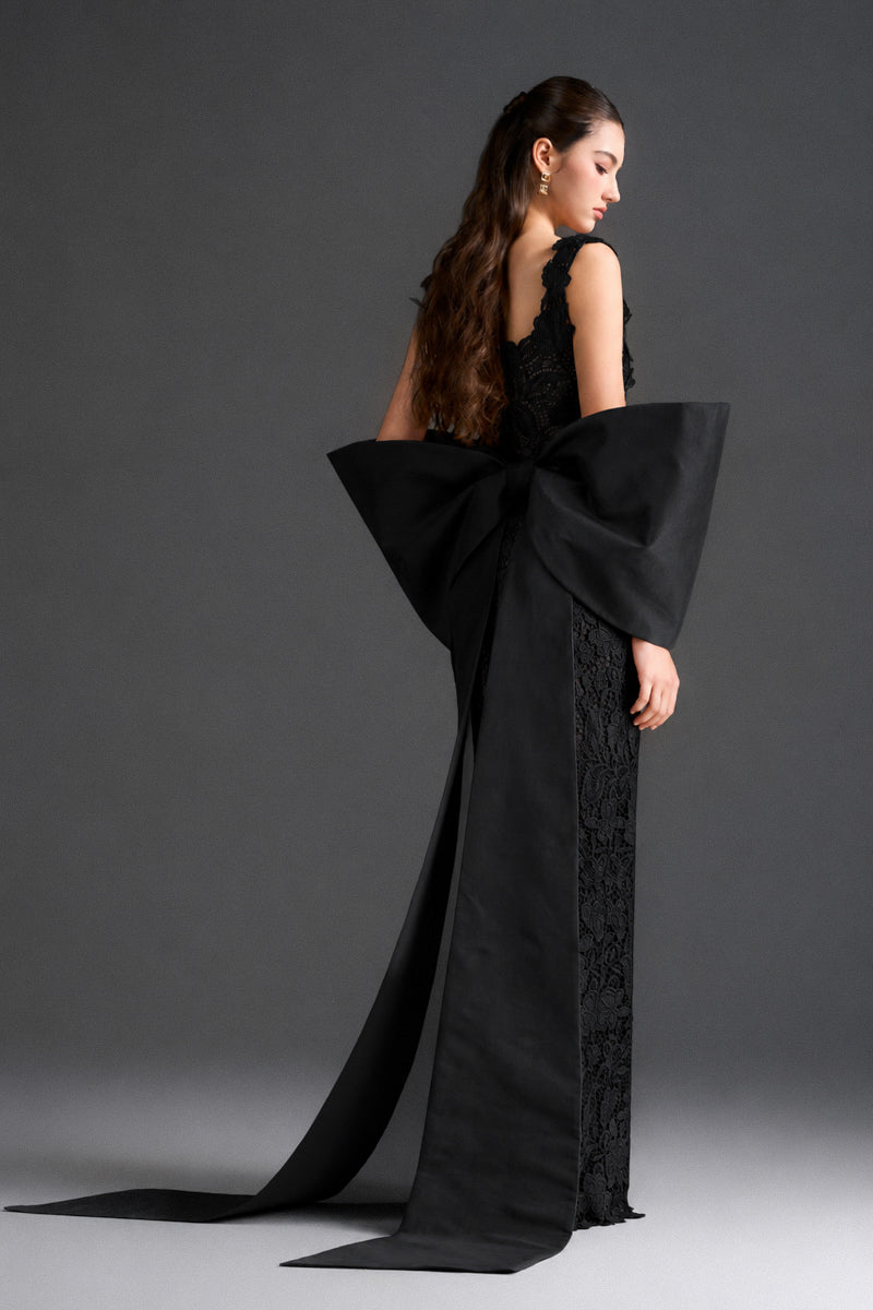 Black floral lace square-neck column gown with large back bow by I.H.F Studio, featuring intricate lace details and elegant design.