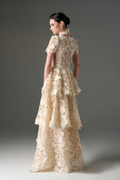 Ivory floral garden lace 3-tiered A-line gown from I.H.F Studio with intricate lace details and flowing fabric.