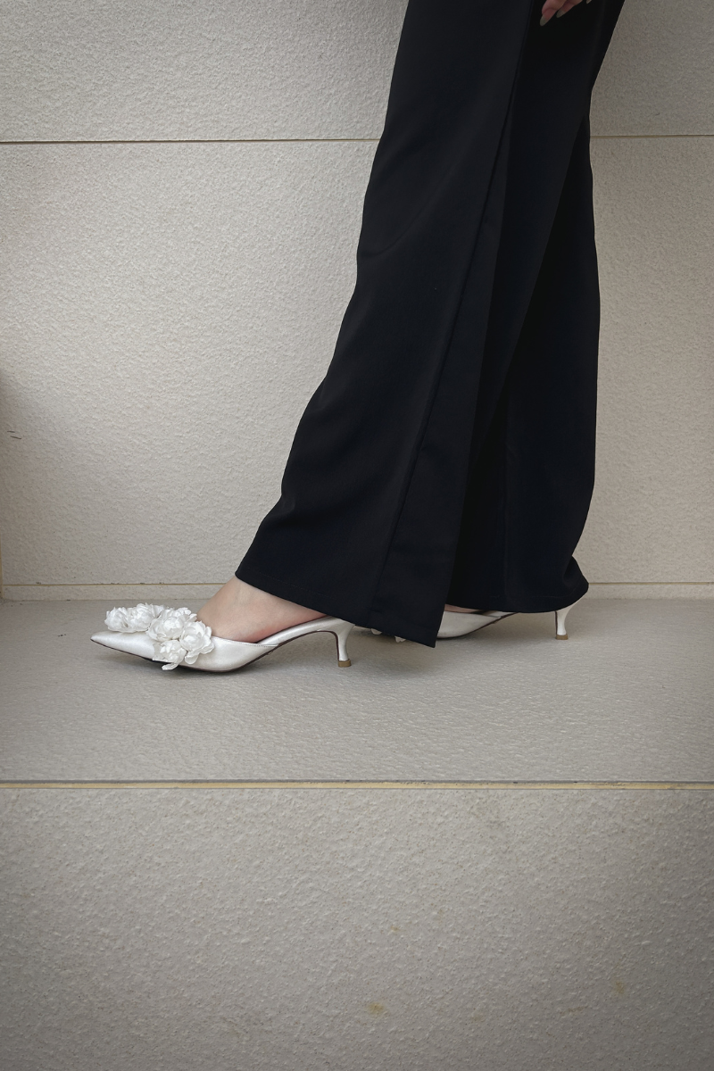 Christin Wu Camelia Cream Bloom Heels shown in a lifestyle image, featuring elegant floral-inspired design and nude color.