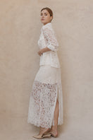 Ivory midi skirt by Entos, featuring a flowy design and elegant fabric, displayed on a hanger.