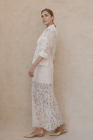 Entos ivory midi skirt featuring a flowy design, shown on a hanger with detailed fabric texture and elegant style.