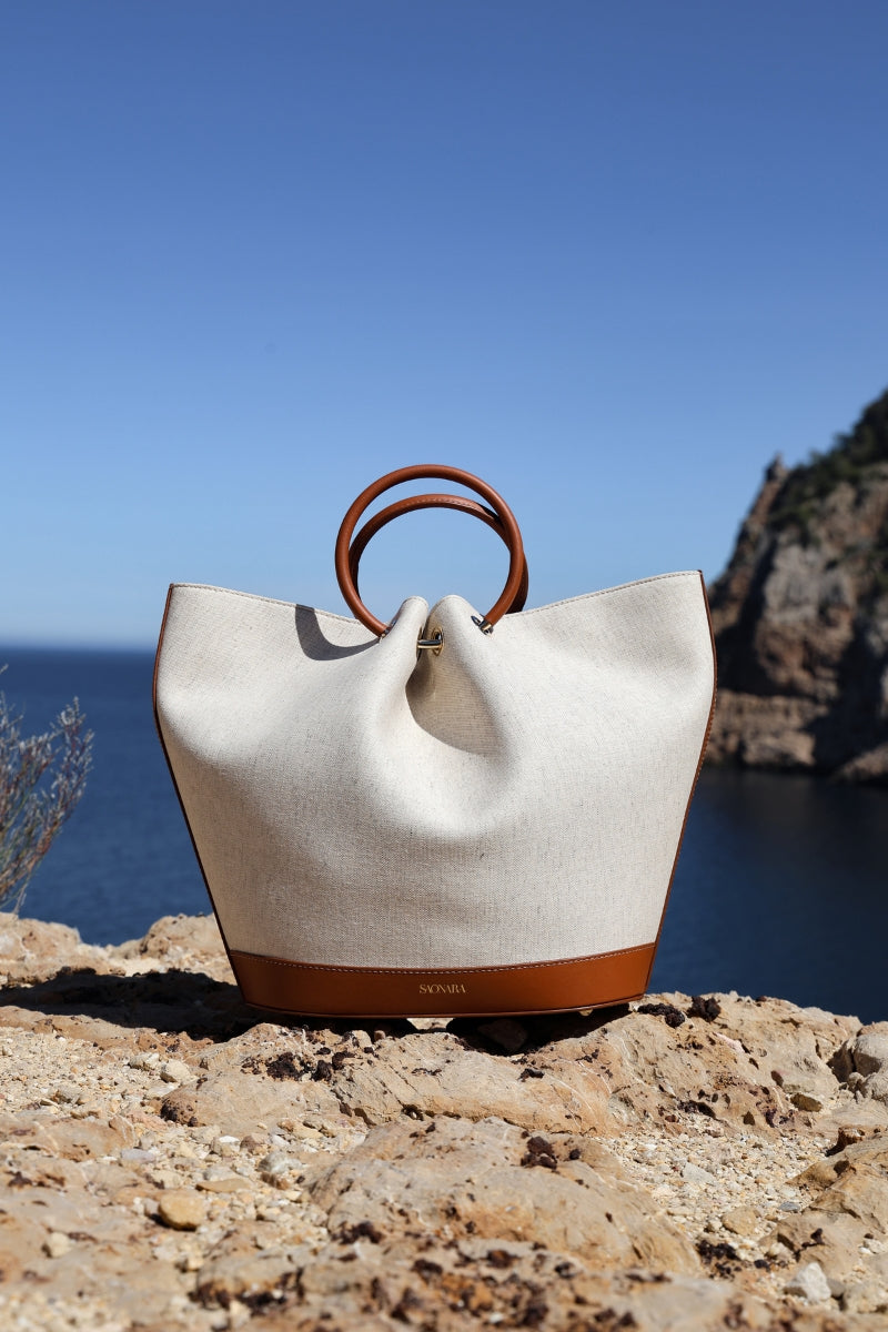 Saonara Capazo linen top handle bag with woven design and sturdy handles, perfect for casual or chic everyday use.