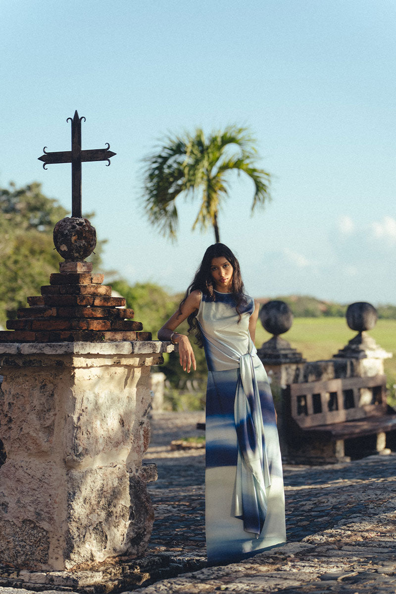 Maylé Vásquez Consta Maxi Dress in lightweight fabric with a flowing silhouette, displayed on a hanger.