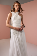 Close-up of a white asymmetrical low waistline gown by Joanna Andraos, showing elegant fabric and detailed design.