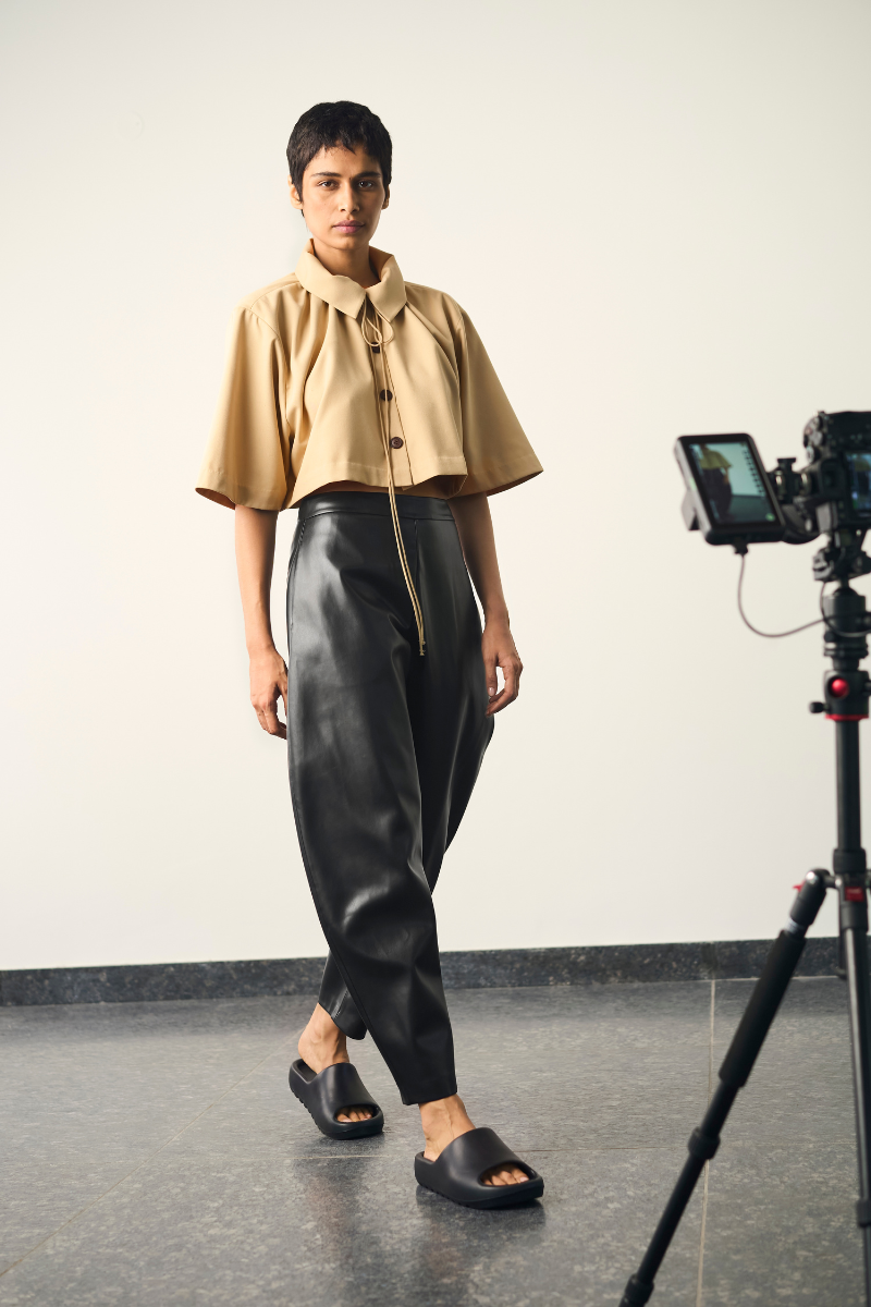 Black URA Lou pants displayed on a model, featuring a relaxed fit and stylish design, perfect for casual or chic outfits.
