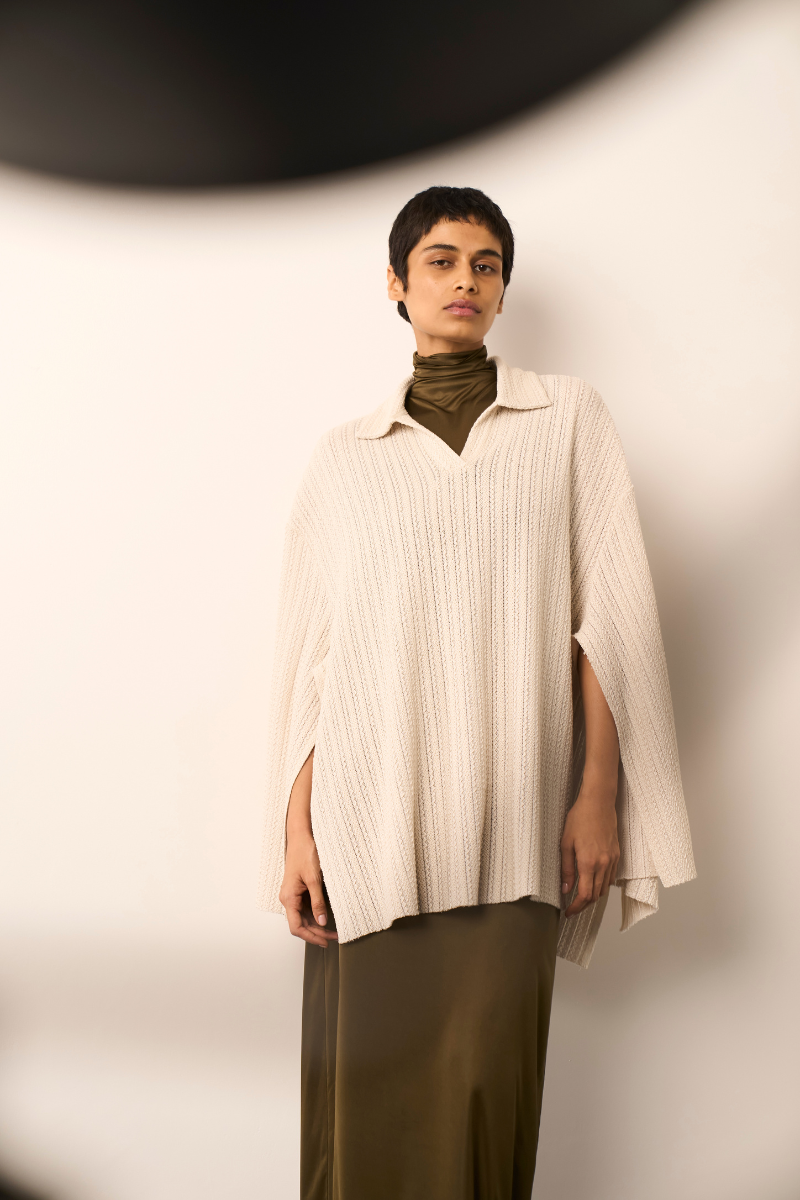 Light ivory ALFIE cape shirt by URA displayed on a hanger, showcasing its elegant design and soft fabric.