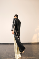 Black MADDIE trench coat by URA, featuring classic design with a tailored fit and stylish lapels, shown on a model.