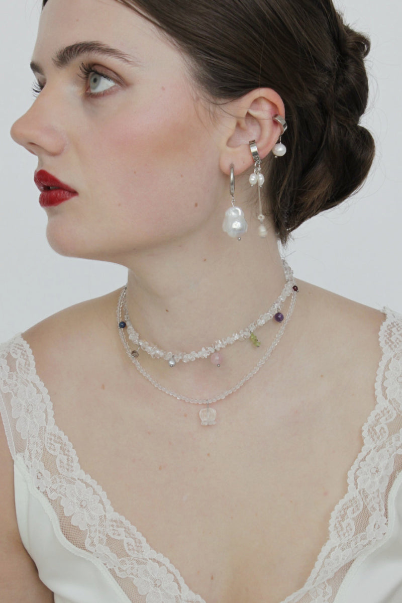 Aethera Alfonso Mix Charms Necklace in white featuring a variety of charm pendants on a delicate chain.