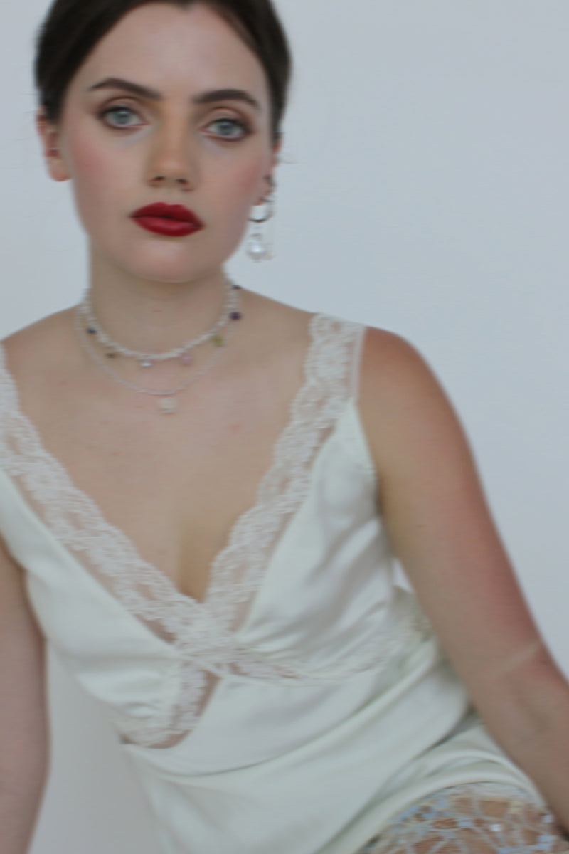 Aethera Muguet Clear Quartz Necklace in white with a delicate string and a polished quartz pendant.