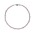 Aethera Tuxi Garnet Clear Quartz Necklace in red with a sleek pendant against a neutral background.
