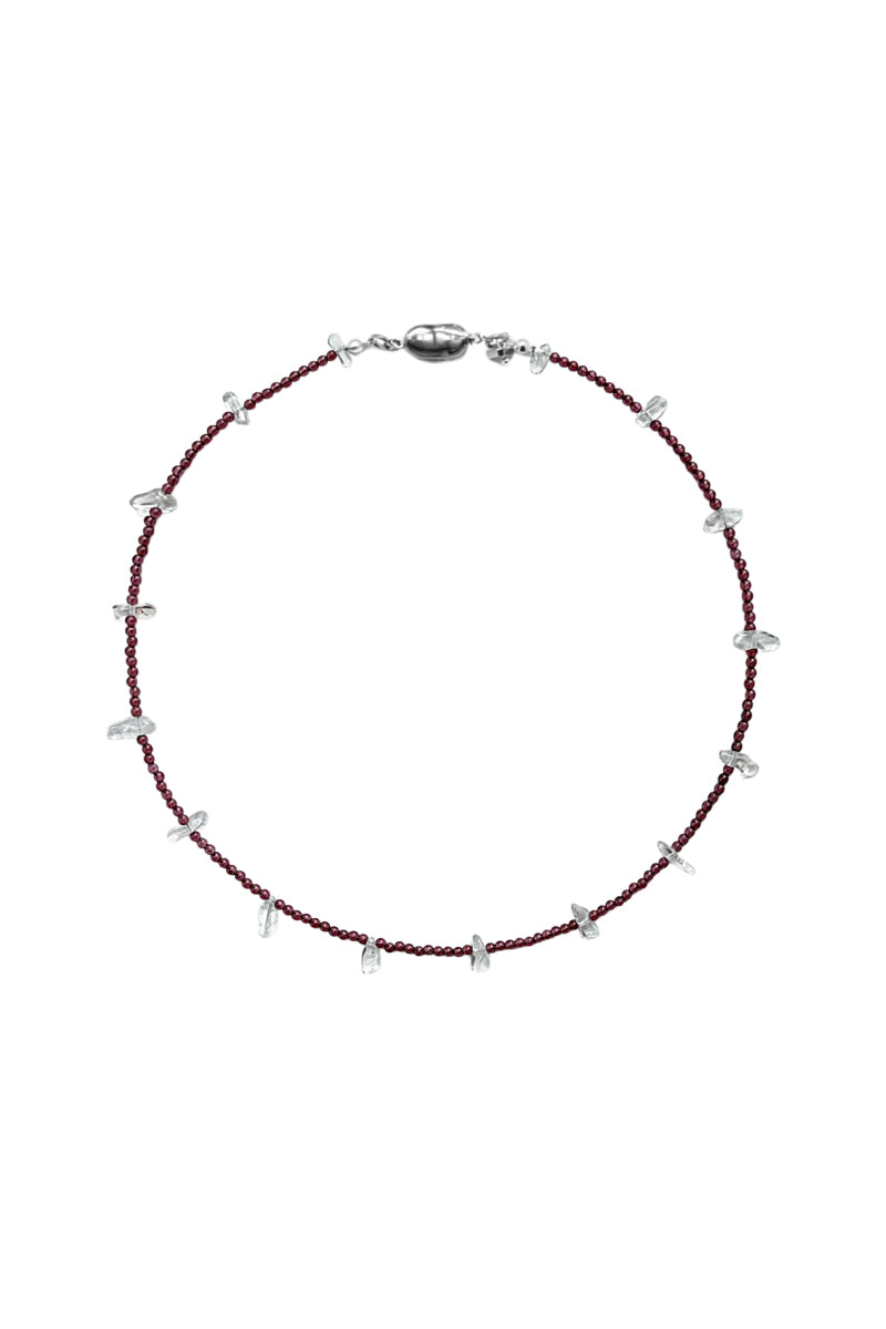 Aethera TUXI Garnet Clear Quartz Necklace featuring a red gemstone pendant on a delicate chain.