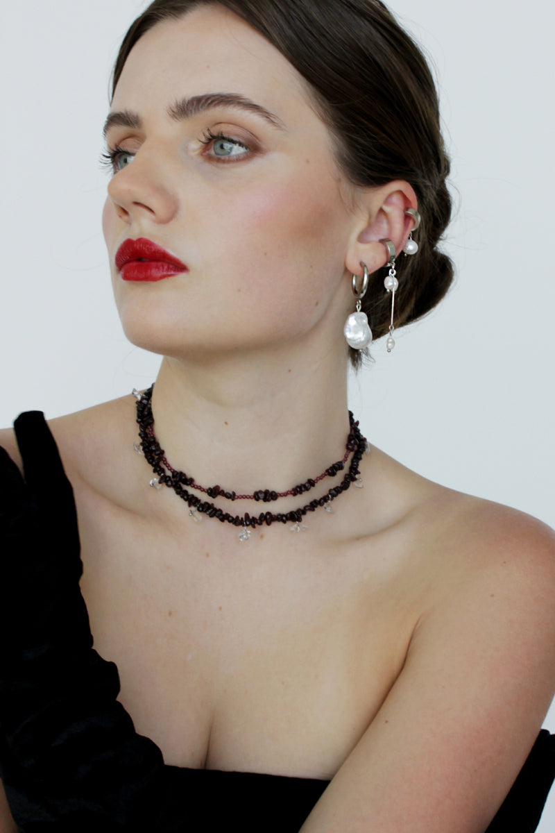 Aethera MUNAI Garnet Clear Quartz Necklace with red gemstones on a delicate chain, showcasing the elegant jewelry design.