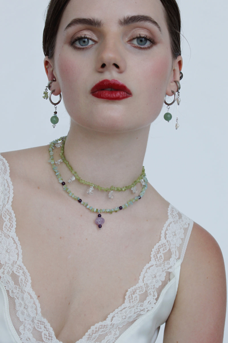 Aethera Toru Peridot necklace featuring a green gemstone pendant on a delicate chain, showcasing vibrant peridot stones.