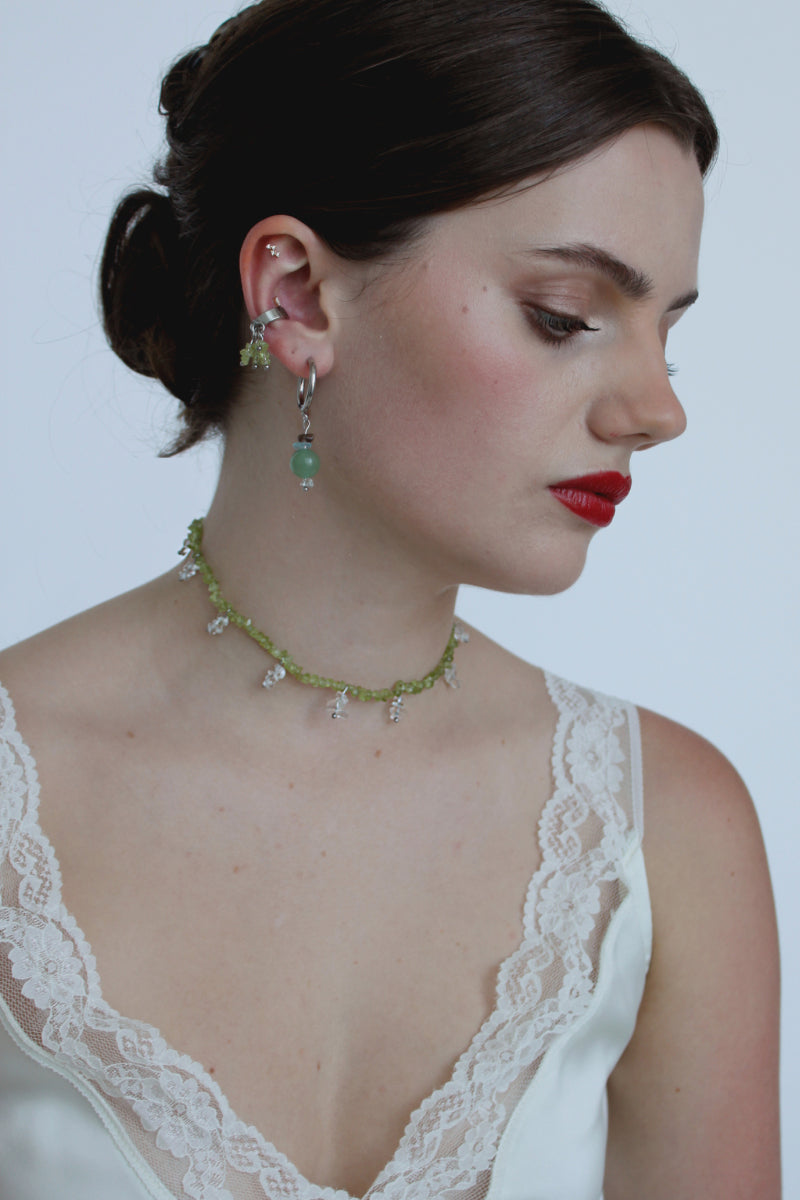 Aethera Toru Peridot Necklace with vibrant green peridot gemstone on a delicate chain, elegant jewelry accessory.