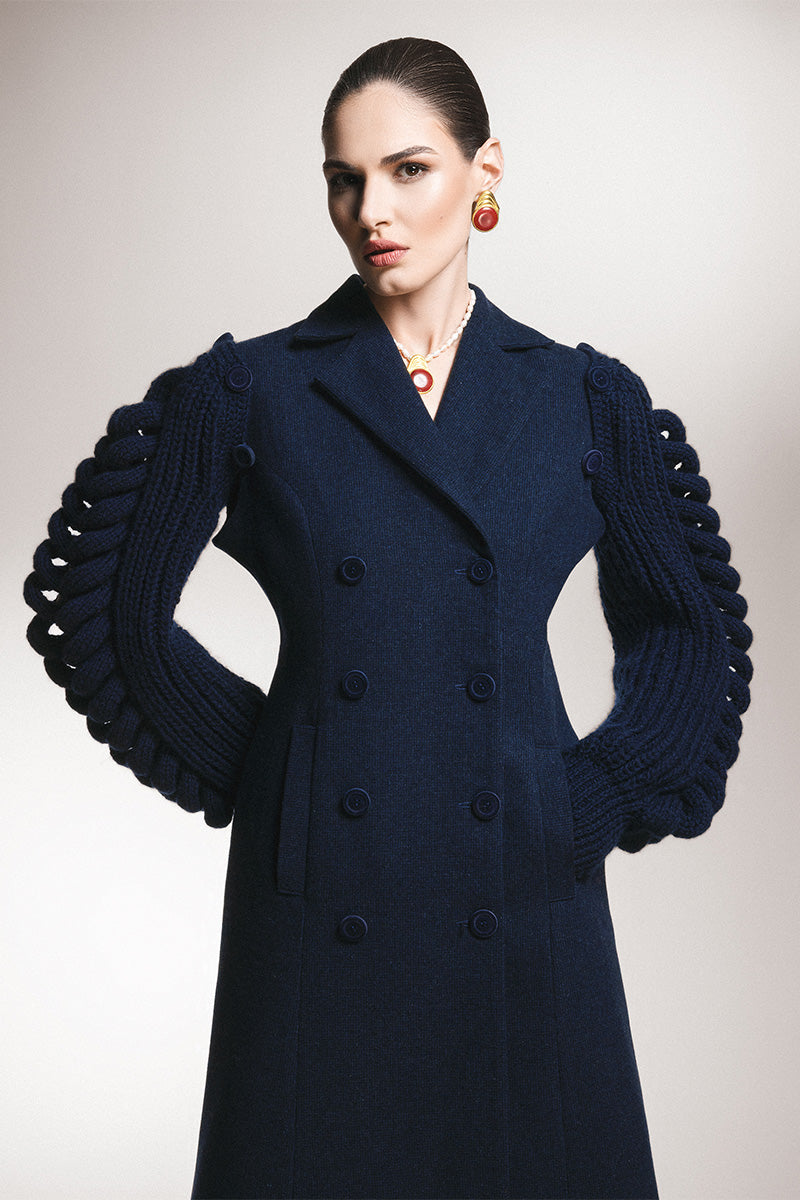 Liya long line navy dress coat hanging on a rack, showcasing a tailored, elegant outerwear piece for women.