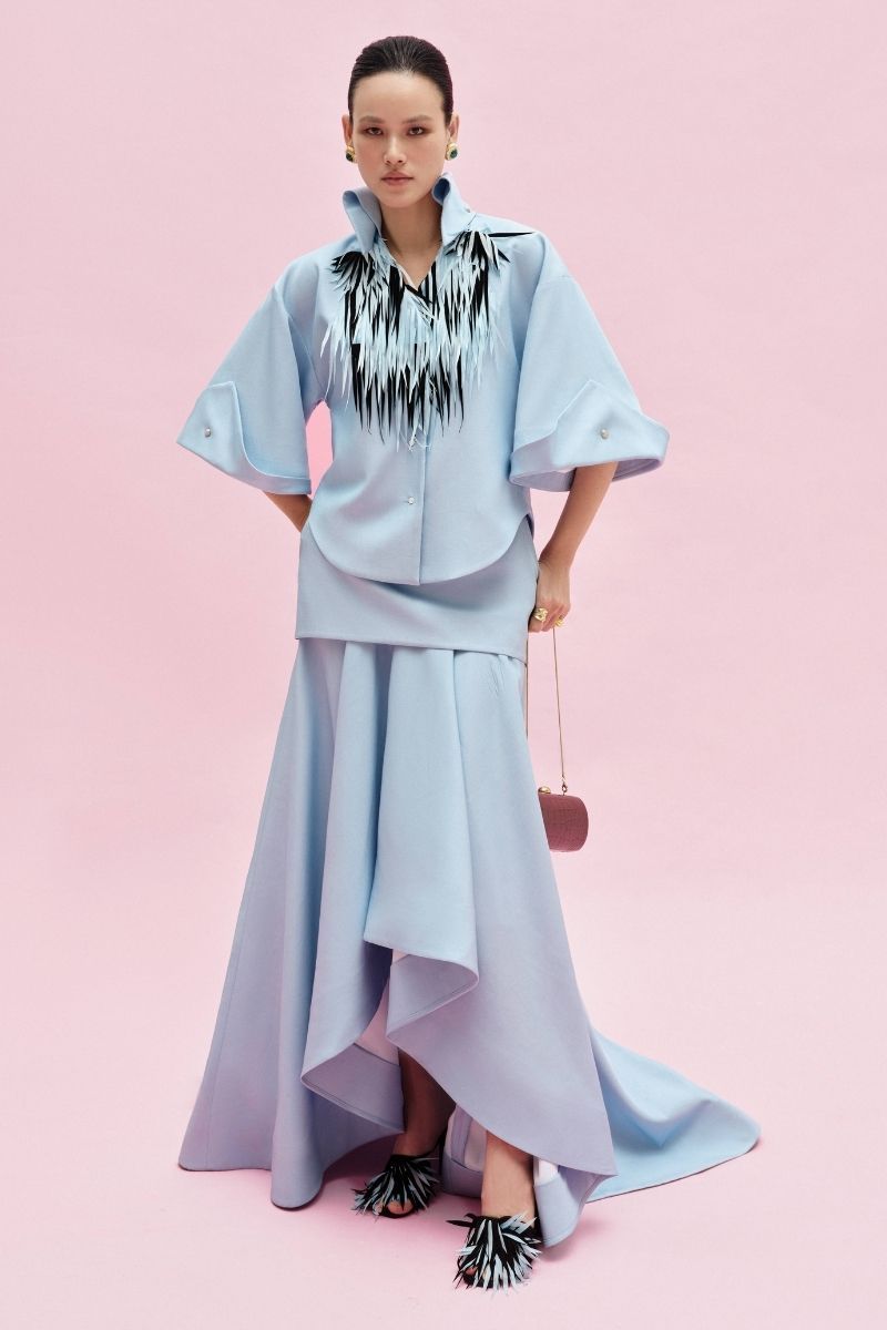 Jenny K Tran Colchester Maxi Skirt in flowy fabric with a high waist and elegant hem detail, shown in a stylish navy color.