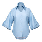 Jenny K Tran Colchester Top, a stylish women's blouse with a relaxed fit and subtle pattern, displayed on a hanger.