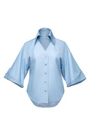 Jenny K Tran Colchester Top, a stylish women's blouse with a relaxed fit and subtle pattern, displayed on a hanger.