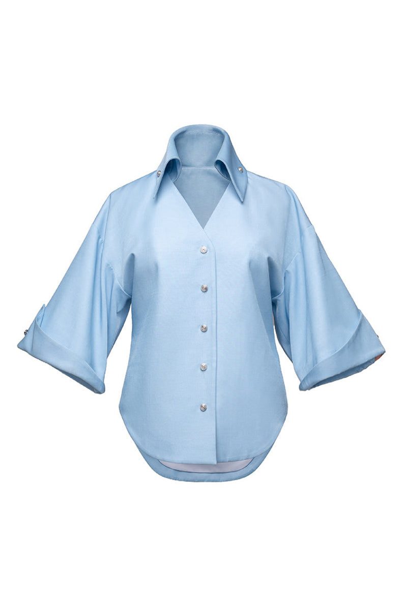 Jenny K Tran Colchester Top, a stylish women's blouse with a relaxed fit and subtle pattern, displayed on a hanger.
