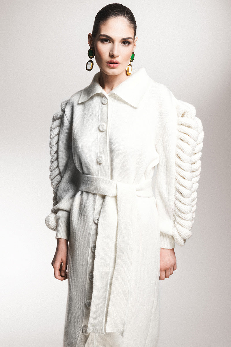Liya dramatic white knit belted coat shown on a model, featuring a stylish design, long sleeves, and a waist belt for a chic look.